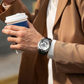 Close-up of a model wearing the TSAR BOMBA Reactor TB8213 staless steel Automatic Interchangeable Men's Watch. Features a sliver stainless steel case and bezel, powered by a Japanese automatic movement. Top dial: minutes; central dial: seconds. Bottom main display: hour hand = pointer reading + central window reading. The TB8213 utilizes the TSAR BOMBA interchangeable module system, allowing for quick and tool-free changes of the strap, bezel, and crown.black strap