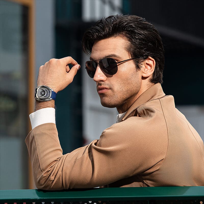 Close-up of a model wearing the TSAR BOMBA Reactor TB8213 staless steel Automatic Interchangeable Men's Watch. Features a sliver stainless steel case and bezel, powered by a Japanese automatic movement. Top dial: minutes; central dial: seconds. Bottom main display: hour hand = pointer reading + central window reading. The TB8213 utilizes the TSAR BOMBA interchangeable module system, allowing for quick and tool-free changes of the strap, bezel, and crown.blue strap