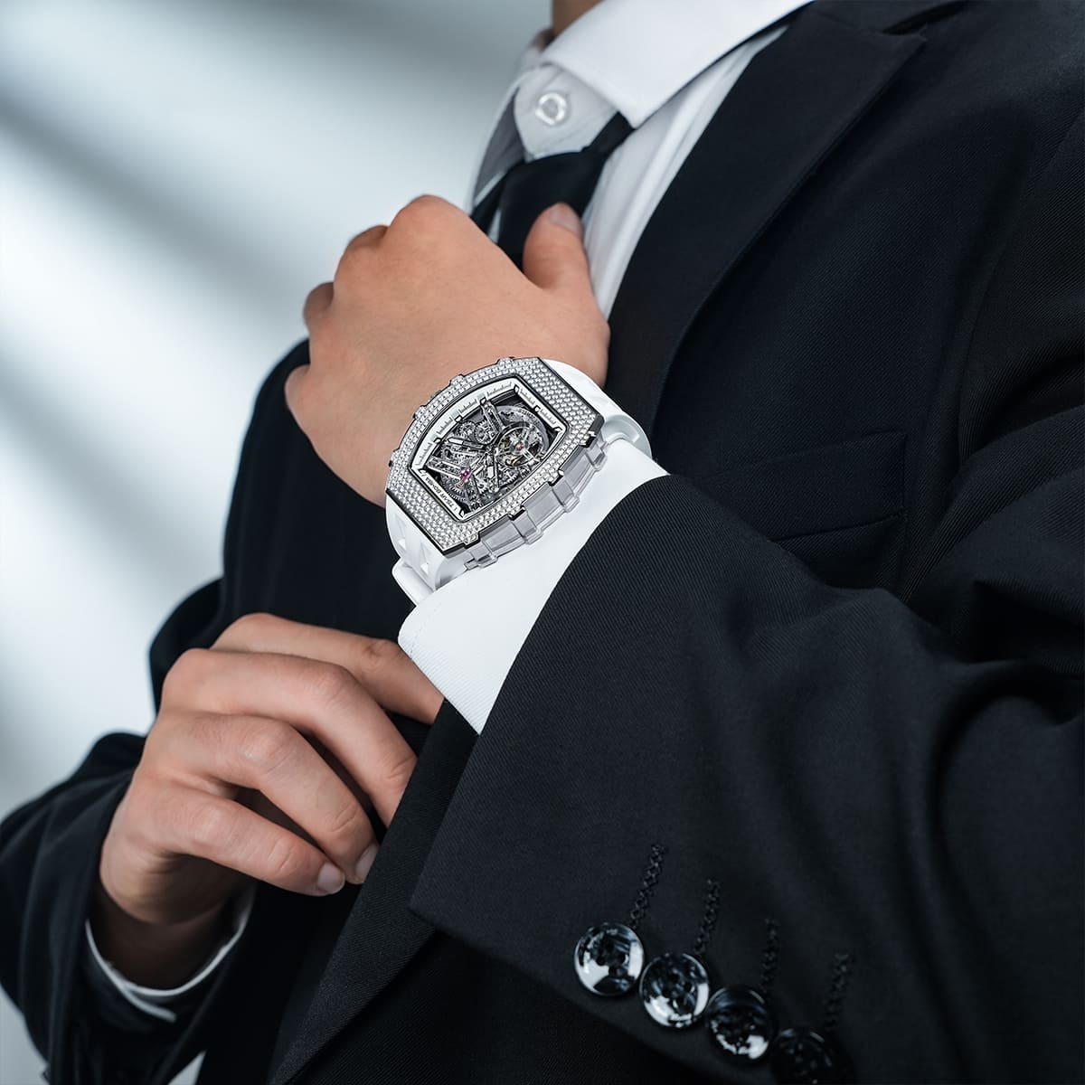 Close-up of a model wearing the TSAR BOMBA Elemental TB8208D men’s White tonneau watch with a gold-tone stainless steel case and cubic zirconia bezel and skeleton dial.