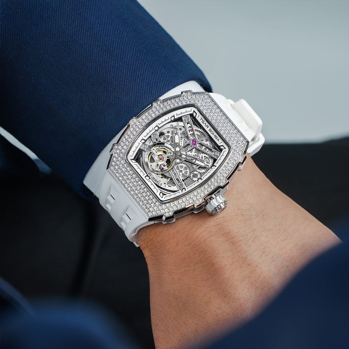 Close-up of a model wearing the TSAR BOMBA Elemental TB8208D men’s White tonneau watch with a gold-tone stainless steel case and cubic zirconia bezel and skeleton dial.