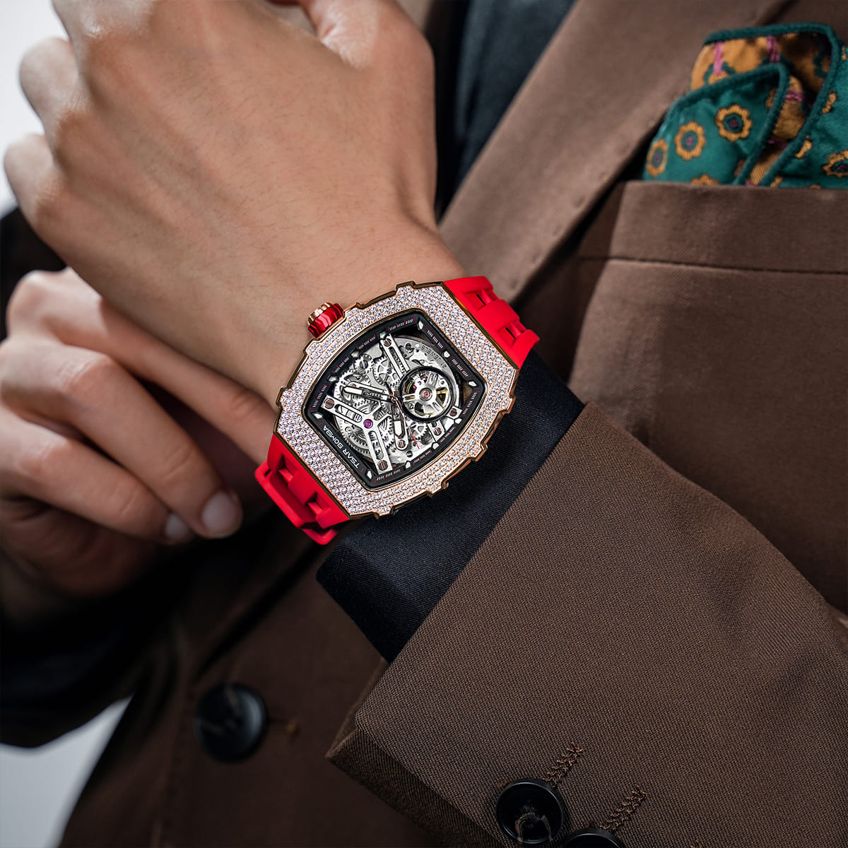 Close-up of a model wearing the TSAR BOMBA Elemental TB8208D men’s Red tonneau watch with a gold-tone stainless steel case and cubic zirconia bezel and skeleton dial.