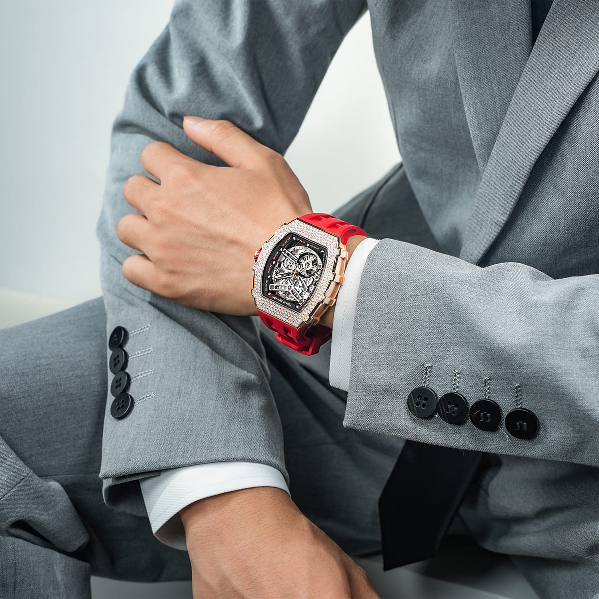 Close-up of a model wearing the TSAR BOMBA Elemental TB8208D men’s Red tonneau watch with a gold-tone stainless steel case and cubic zirconia bezel and skeleton dial.