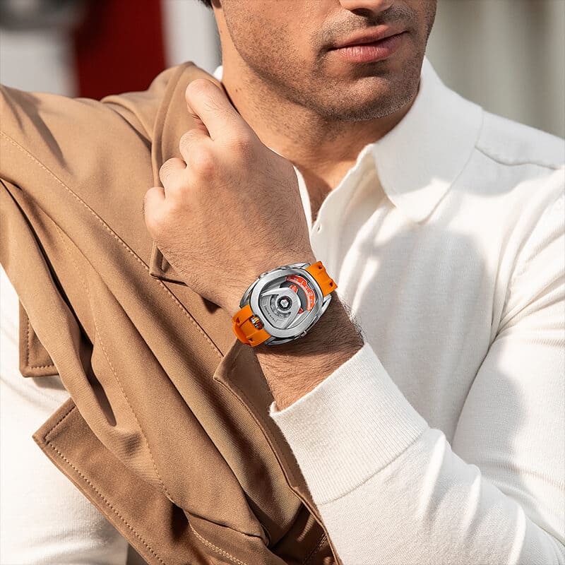 Close-up of a model wearing the TSAR BOMBA Reactor TB8213 staless steel Automatic Interchangeable Men's Watch. Features a sliver stainless steel case and bezel, powered by a Japanese automatic movement. Top dial: minutes; central dial: seconds. Bottom main display: hour hand = pointer reading + central window reading. The TB8213 utilizes the TSAR BOMBA interchangeable module system, allowing for quick and tool-free changes of the strap, bezel, and crown.orange strap