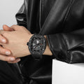 Close-up of a model wearing the TSAR BOMBA Elemental TB8210CF Cool Black men’s tonneau watch, featuring a tonneau stainless steel case, a carbon fiber bezel, and black strap. The Seiko Epson automatic movement is displayed with a tourbillon at 9 o’clock, a power reserve indicator at 12 o’clock, and a 24-hour display at 6 o’clock.